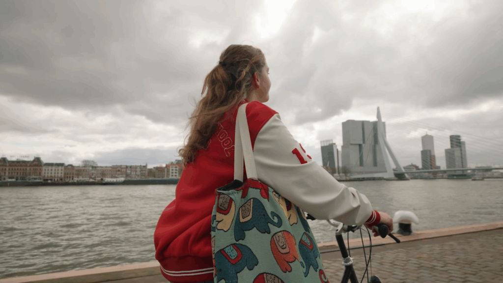 Student met ESL jas op de fiets over de Maasboulevard